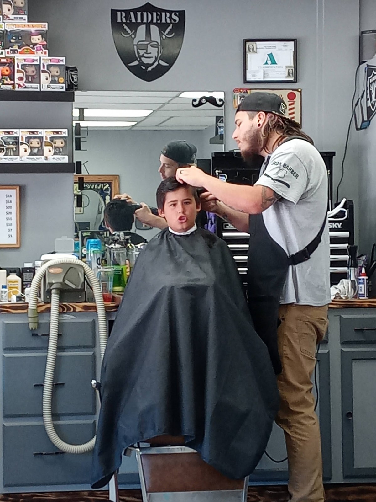 A barber working on a customer's haircut inside Iron Barber